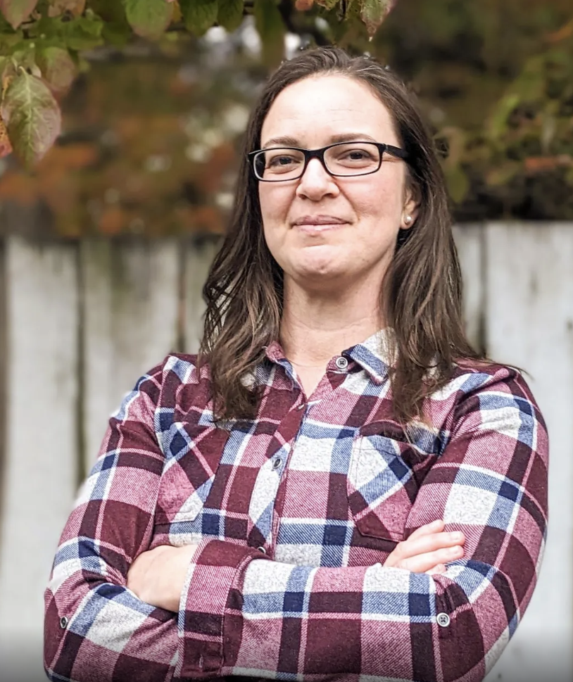 Sarah Taber standing in front of a fence